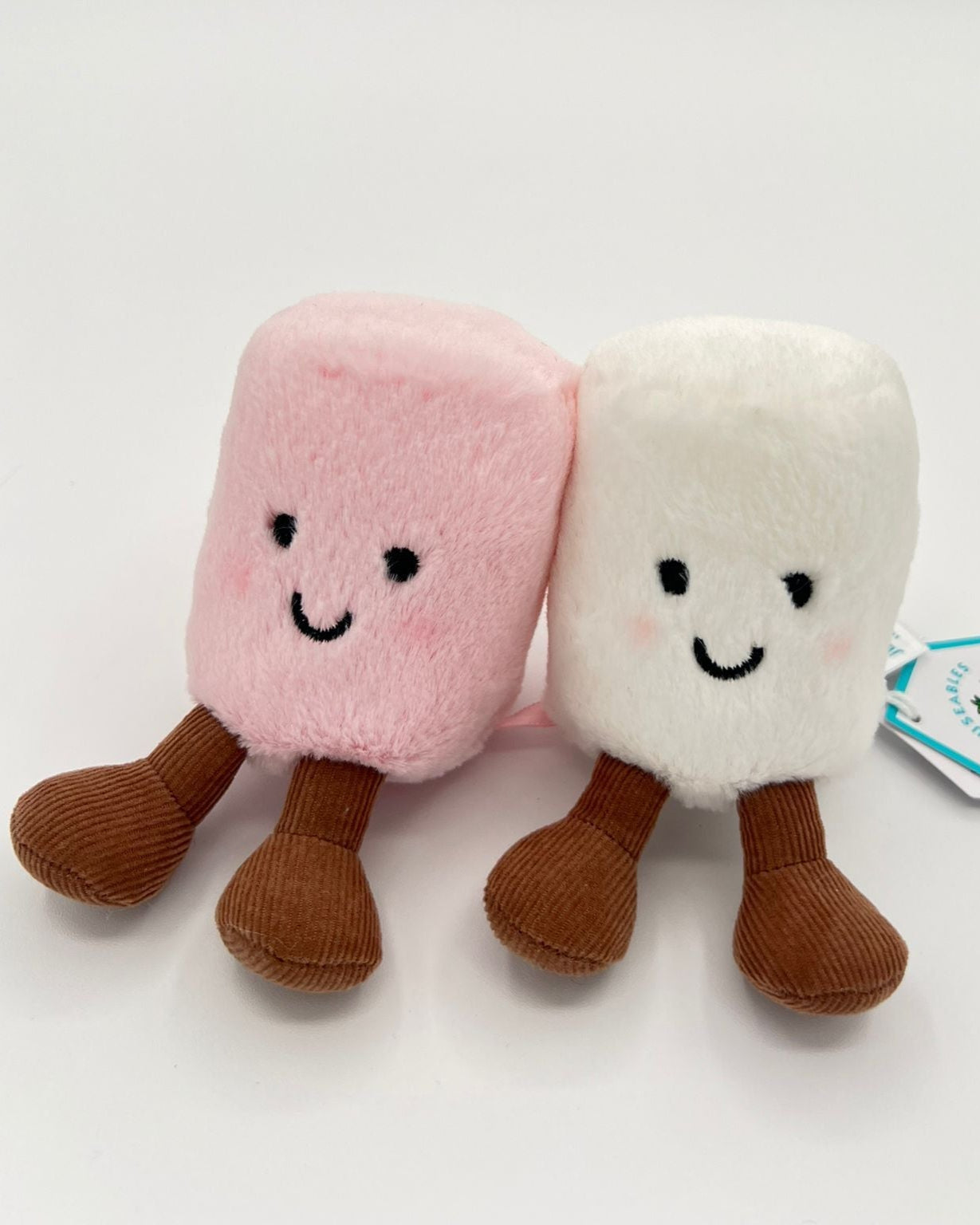 Two plush toys resembling pink and white marshmallows with a smiling face on a white background.