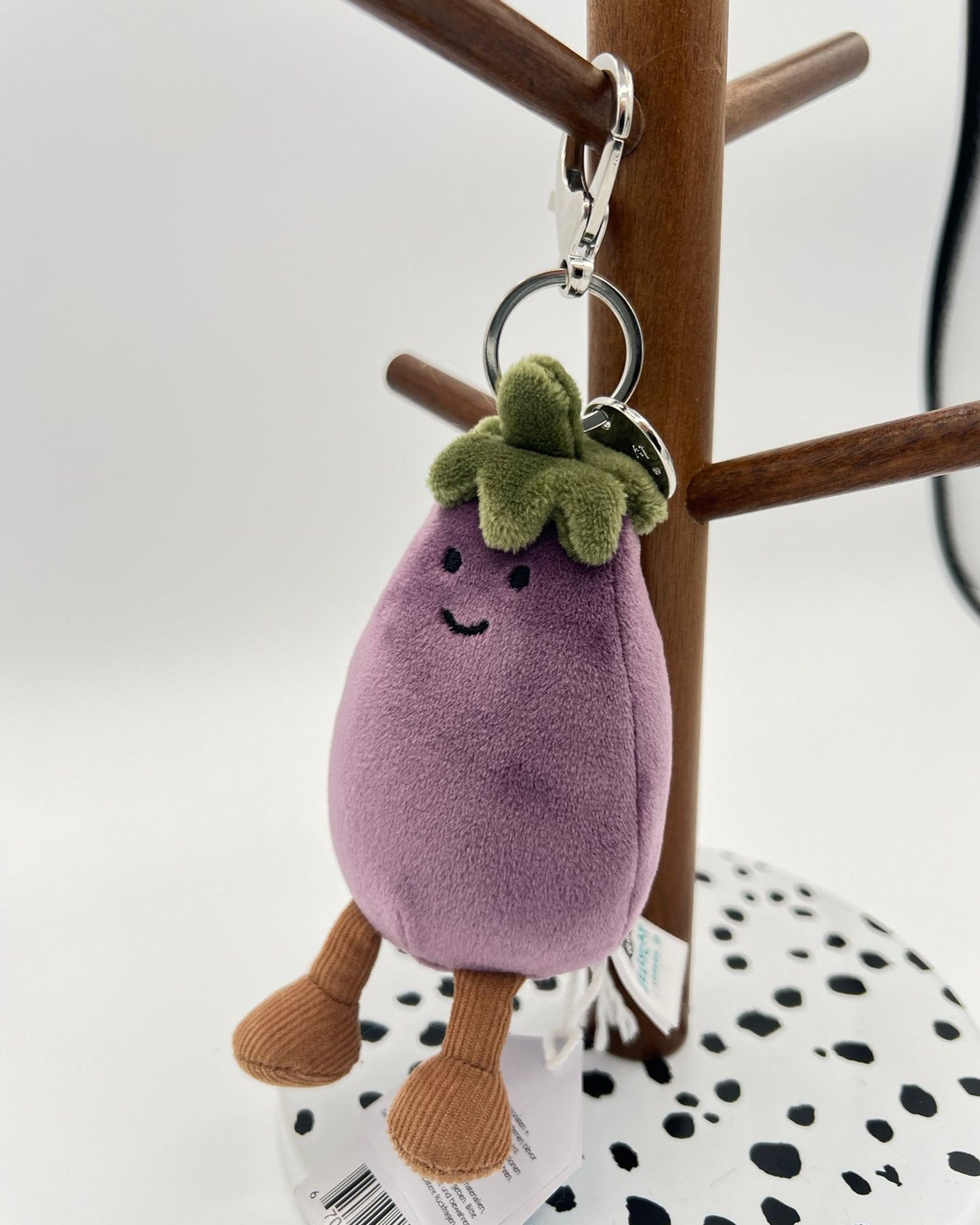 Plush keychain shaped like an eggplant with a smiling face