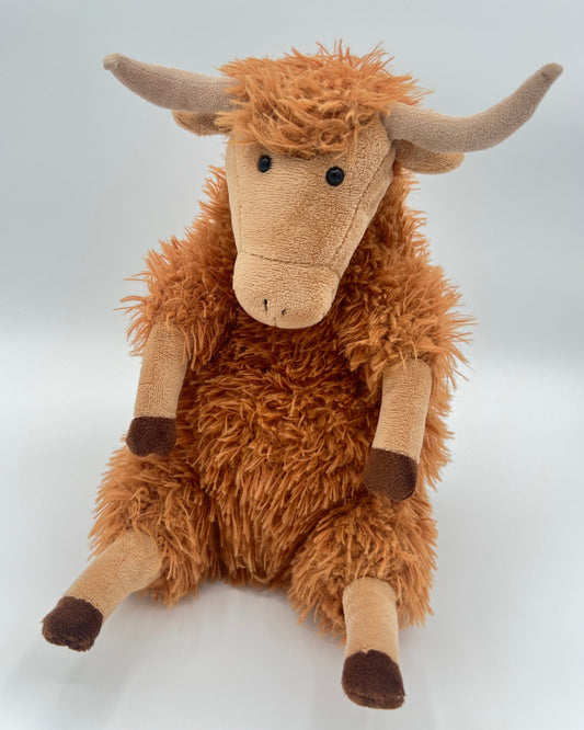 Plush toy highland cow on a white background